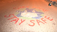 Delhi police personnel paint on road to spread COVID-19 awareness