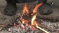 People sit around bonfires as temperature plummets in Delhi