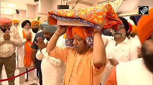 Yogi carries the Guru Granth Sahib on his head as the holy book arrived at his official residence