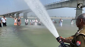 Officers take nectar bath with the holy water of Triveni Sangam in Ayodhya