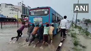 Vehicles struggle to cross a severely waterlogged road in Gujarat's Tharad following heavy rain