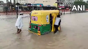 Vehicles struggle to cross a severely waterlogged road in Gujarat's Tharad following heavy rain